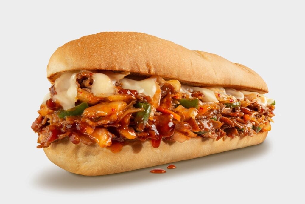 KIMCHI CHEESESTEAK - USDA Choice Steak, Gochujang Sauce, Sautéed Onions, Peppers, Kimchi, Provolone Cheese, Sriracha Mayo